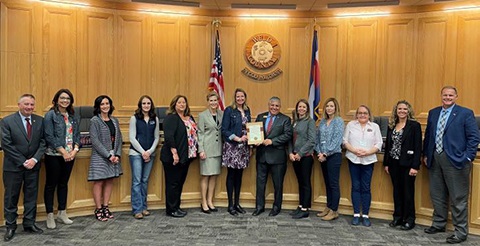 Representatives from the Department of Human Services and Area Agency on Aging standing with the Board of Commissioners.