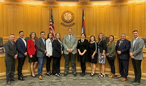 The Weld County Board of Commissioners standing with members of the Department of Human Services and Larimer County Commissioner Kristin Stephens.
