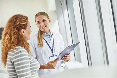 Woman speaks with doctor during her women's wellness exam