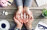 Adult hands holding child's hands, holding paper people