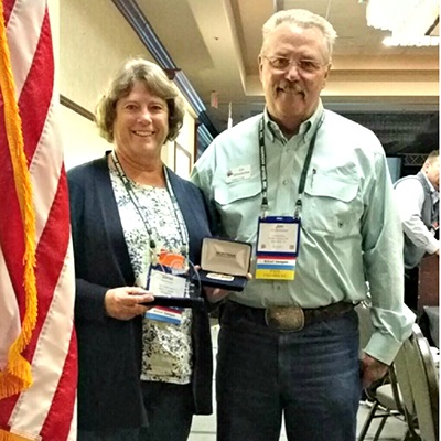 Weld County Fair Coordinator poses with her awards including Fair Manager of the Year.