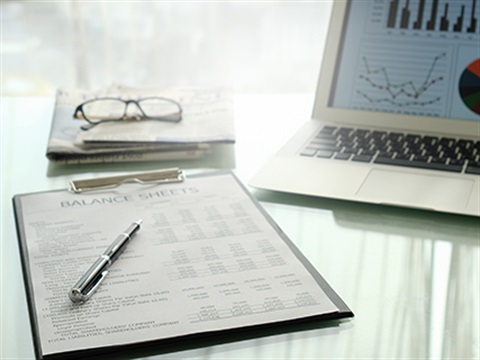Report sitting on desk next to a laptop