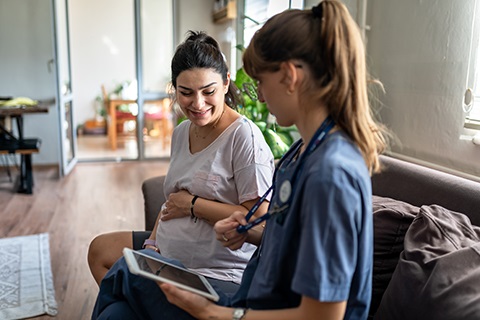 Nurse Home Practitioner sitting with a pregnant woman
