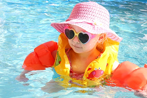 Child wearing floaties in a pool