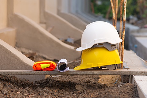 Hard hats sitting on a construction site next to a building.