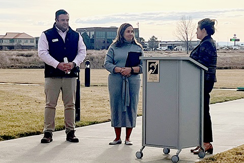 Commissioner Ross, Congresswoman Caraveo and Commissioner Saine standing at a podium to announce Weld County as a Safe Streets and Roads for All grant recipient. 