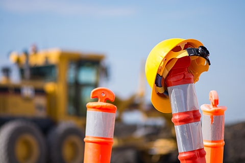 A hard hat with construction equipment in the background.