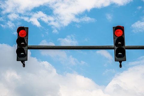 A stoplight up against a blue sky.