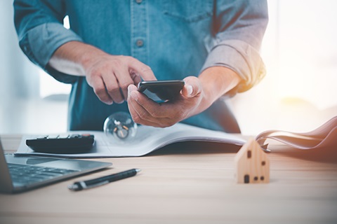 A person looks at a phone while working on a permitting project.