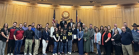 Department of human services staff and Weld County foster families standing with the Weld County Board of Commissioners.