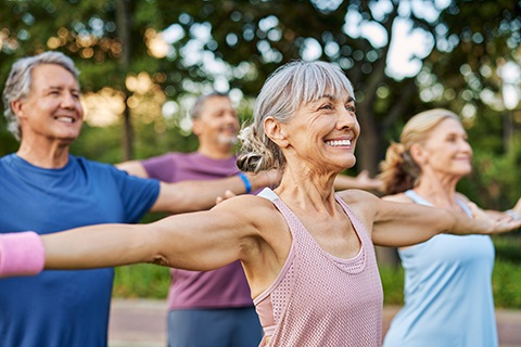 A group of adults exercise in a park.