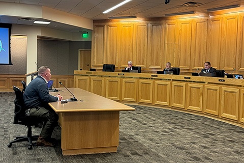 Oil and Gas Energy Director Brett Cavanagh sitting in the Centennial Hearing Room presenting to the Weld County Board of Commissioners.