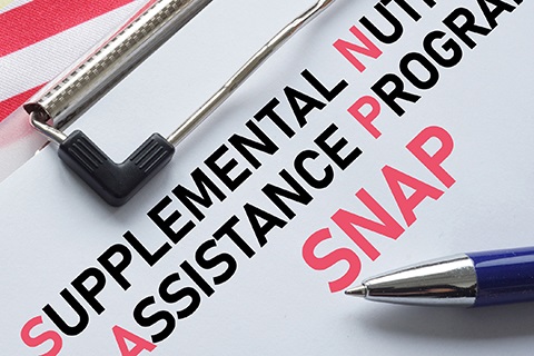 A Supplemental Nutrition Assistance Program form on a clipboard with a pen.