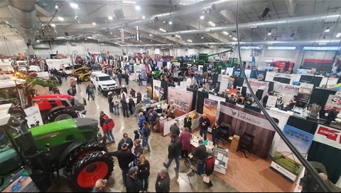 Colorado Farm Show as seen from above with large tractors and numerous attendees exploring vendor booths.