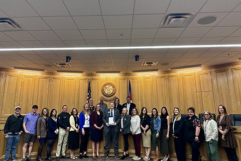 Weld County Department of Human Services staff stand with the board of commissioners.